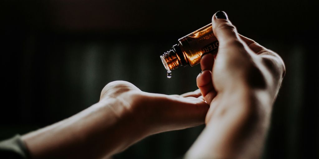 person holding amber glass bottle